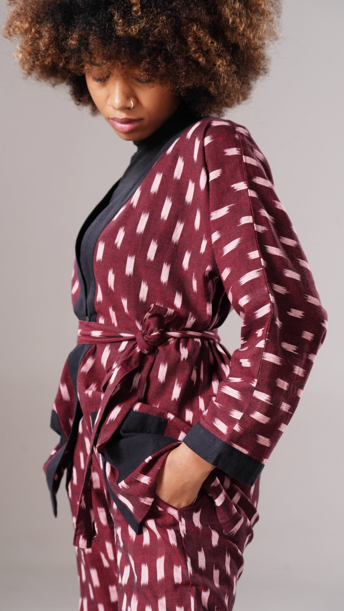 Woman wearing a patterned robe against a neutral background