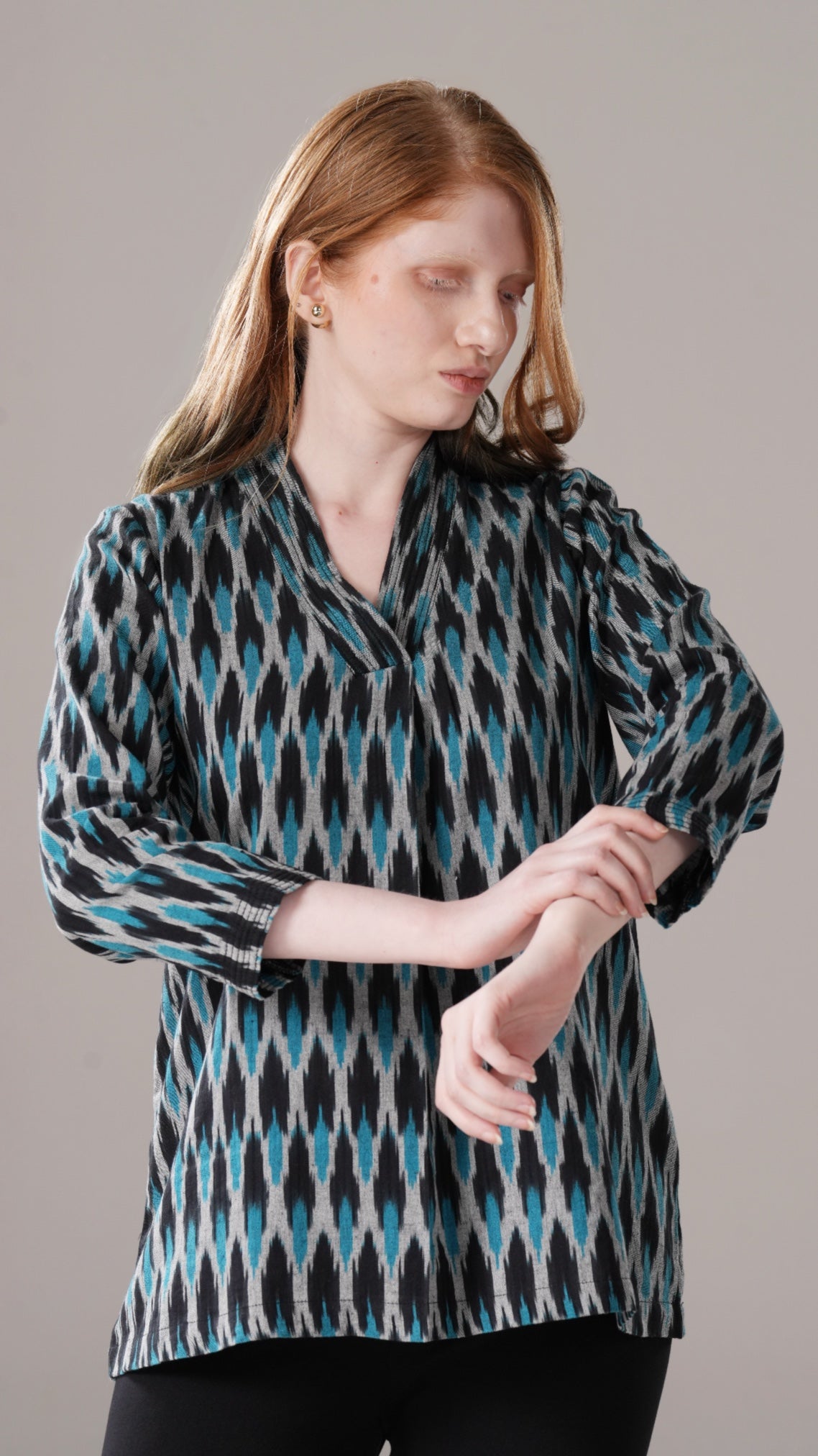 Woman wearing a patterned shirt against a plain background