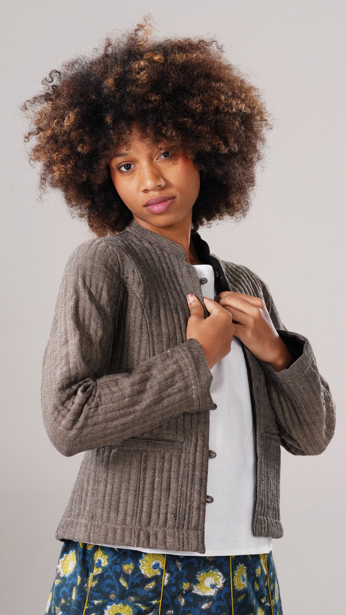 Woman wearing a brown knitted cardigan against a plain background