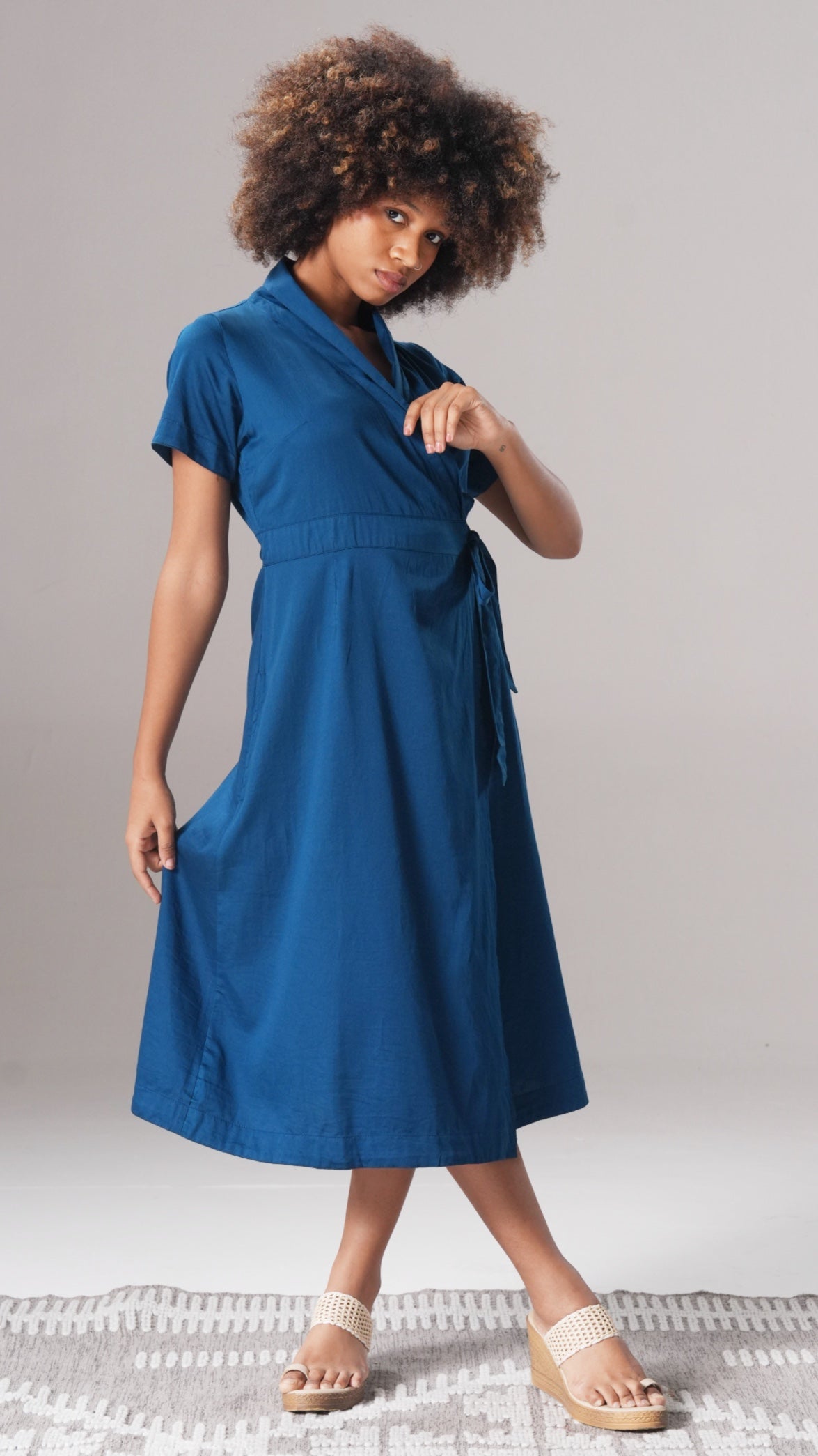 Woman wearing a blue dress on a plain background
