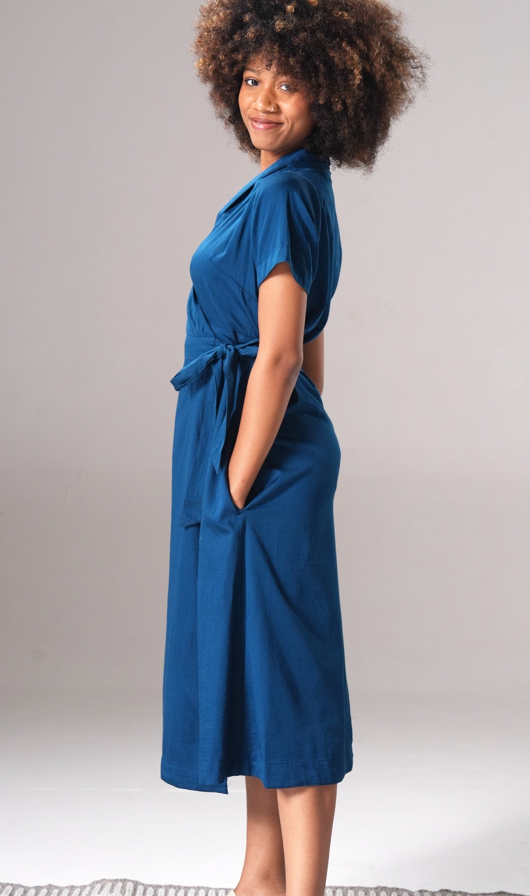 Woman wearing a blue dress against a plain background