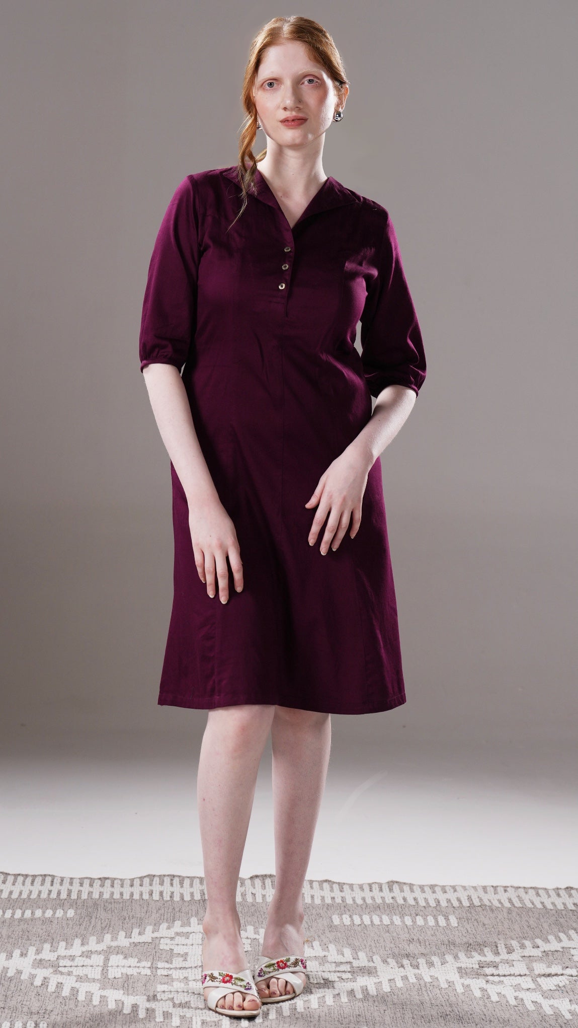 Woman wearing a purple dress against a neutral background