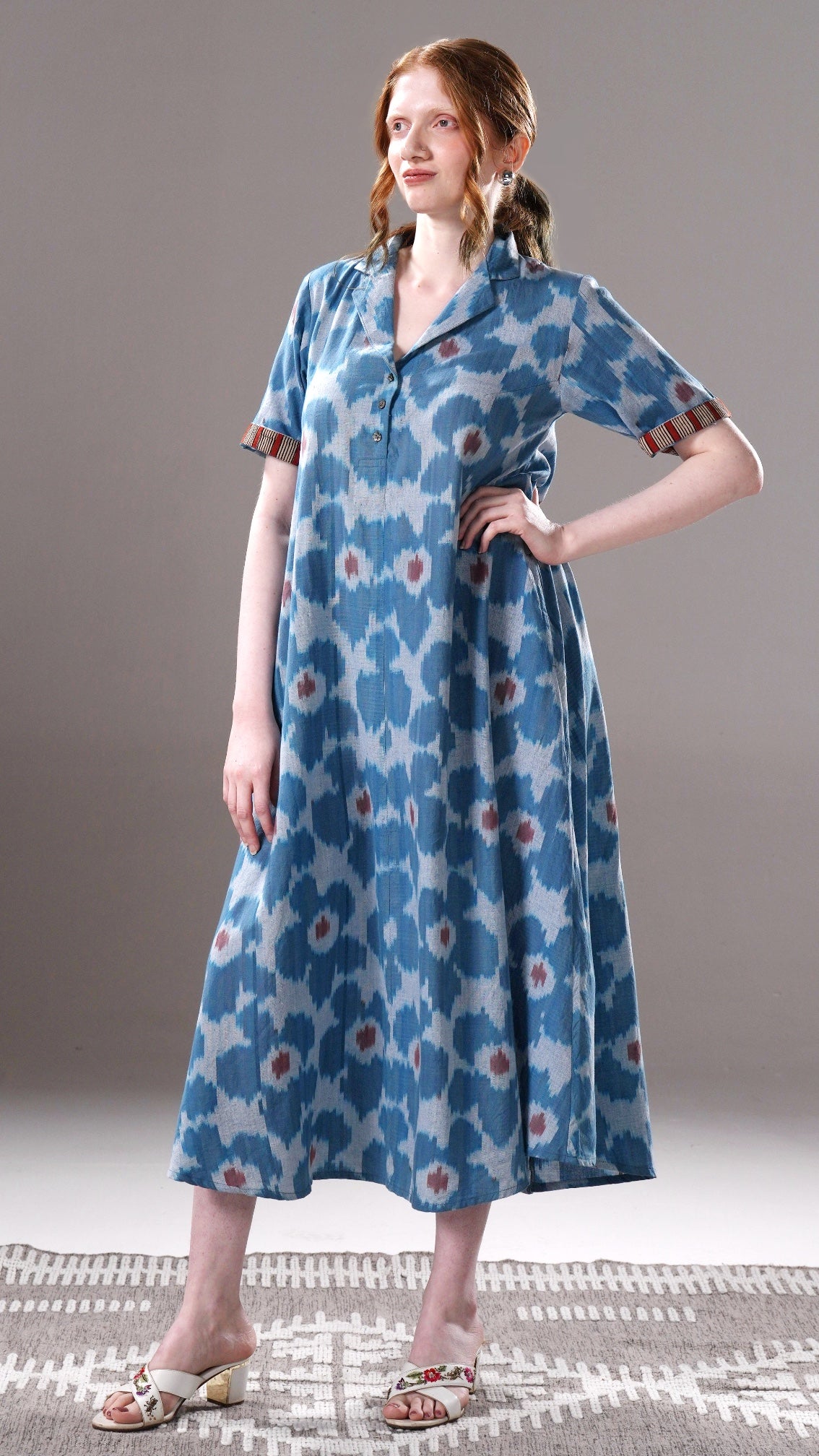 Woman wearing a blue floral dress on a gray background