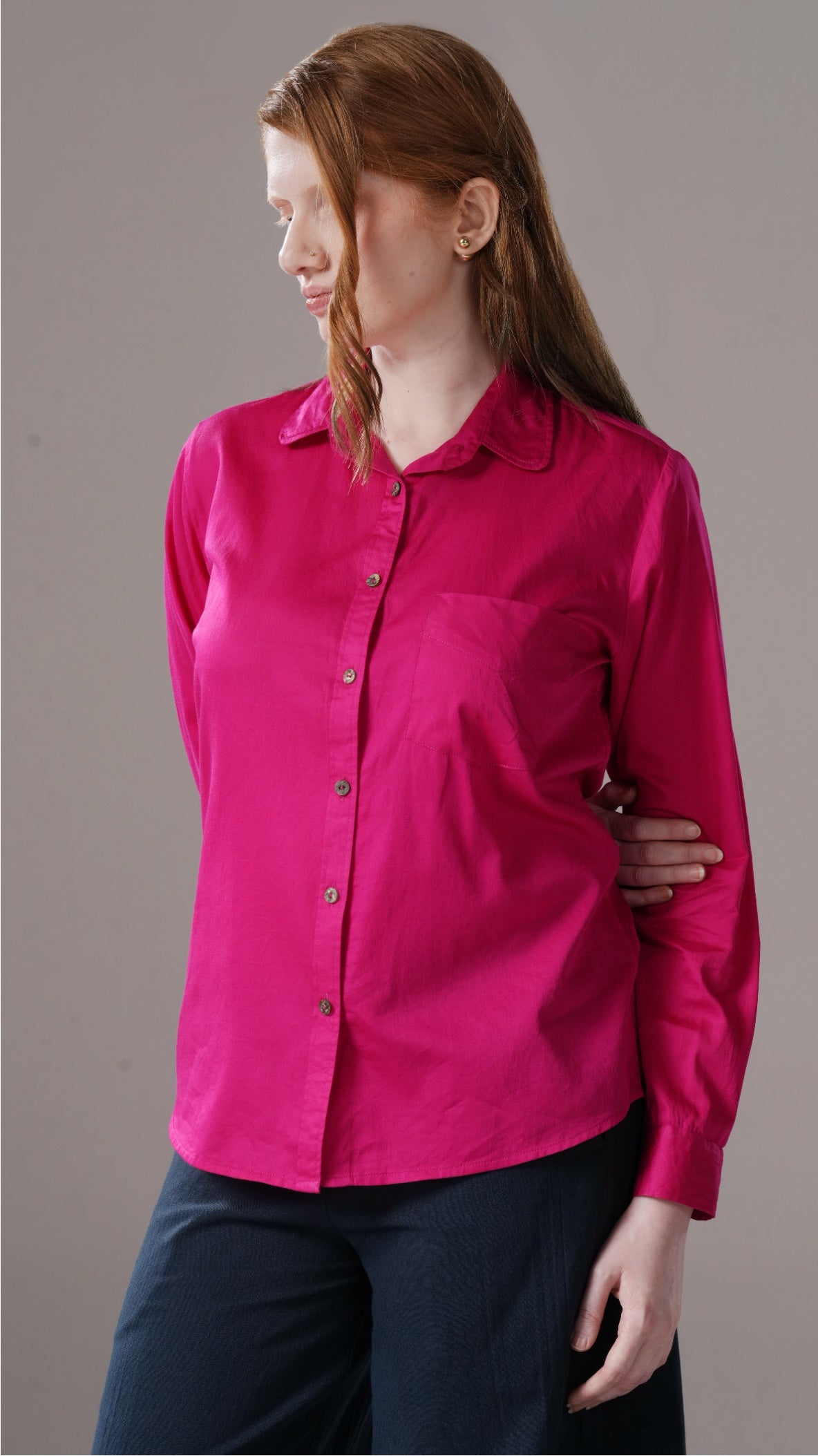 Person wearing a bright pink shirt against a gray background
