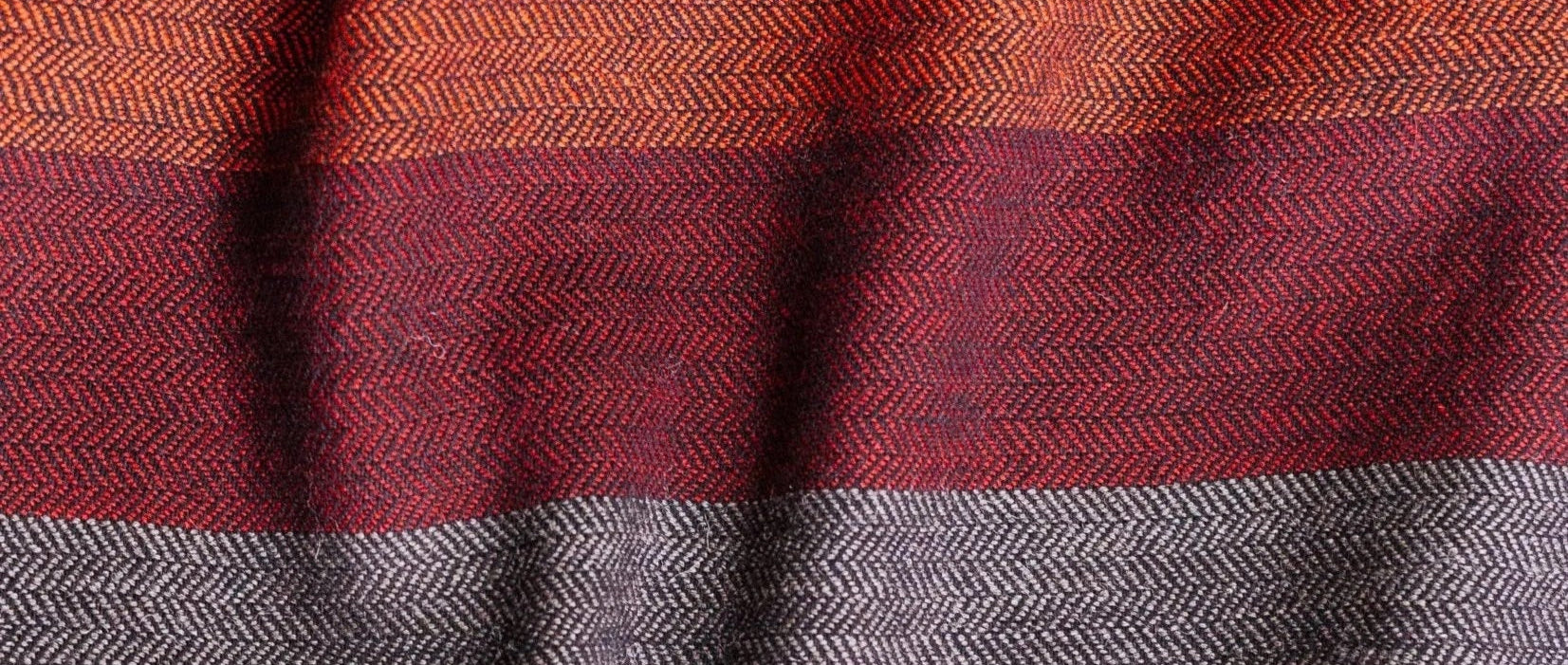 Close-up of fabric with red, gray, and orange stripes
