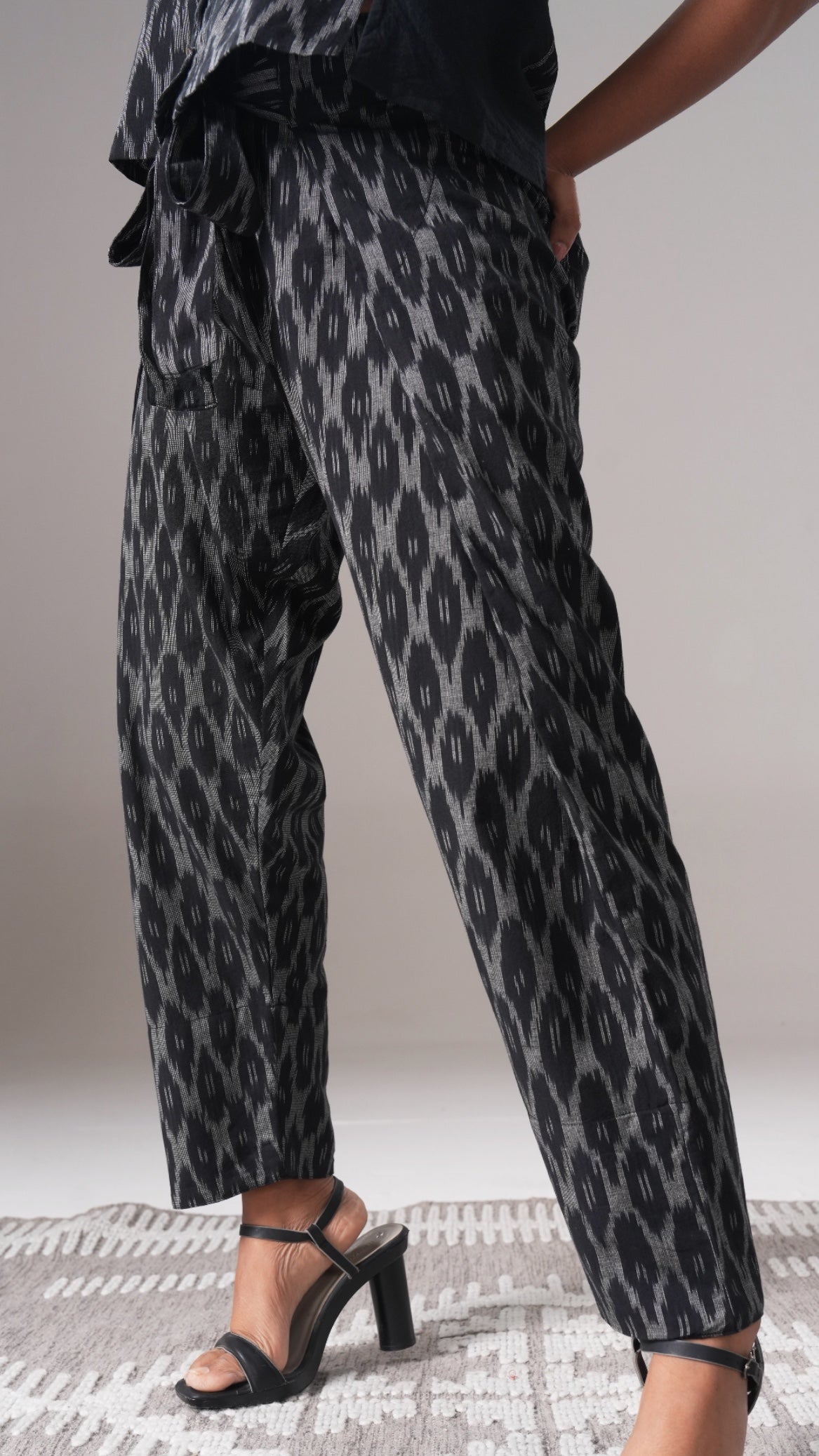 Leopard print pants worn by a person on a neutral background