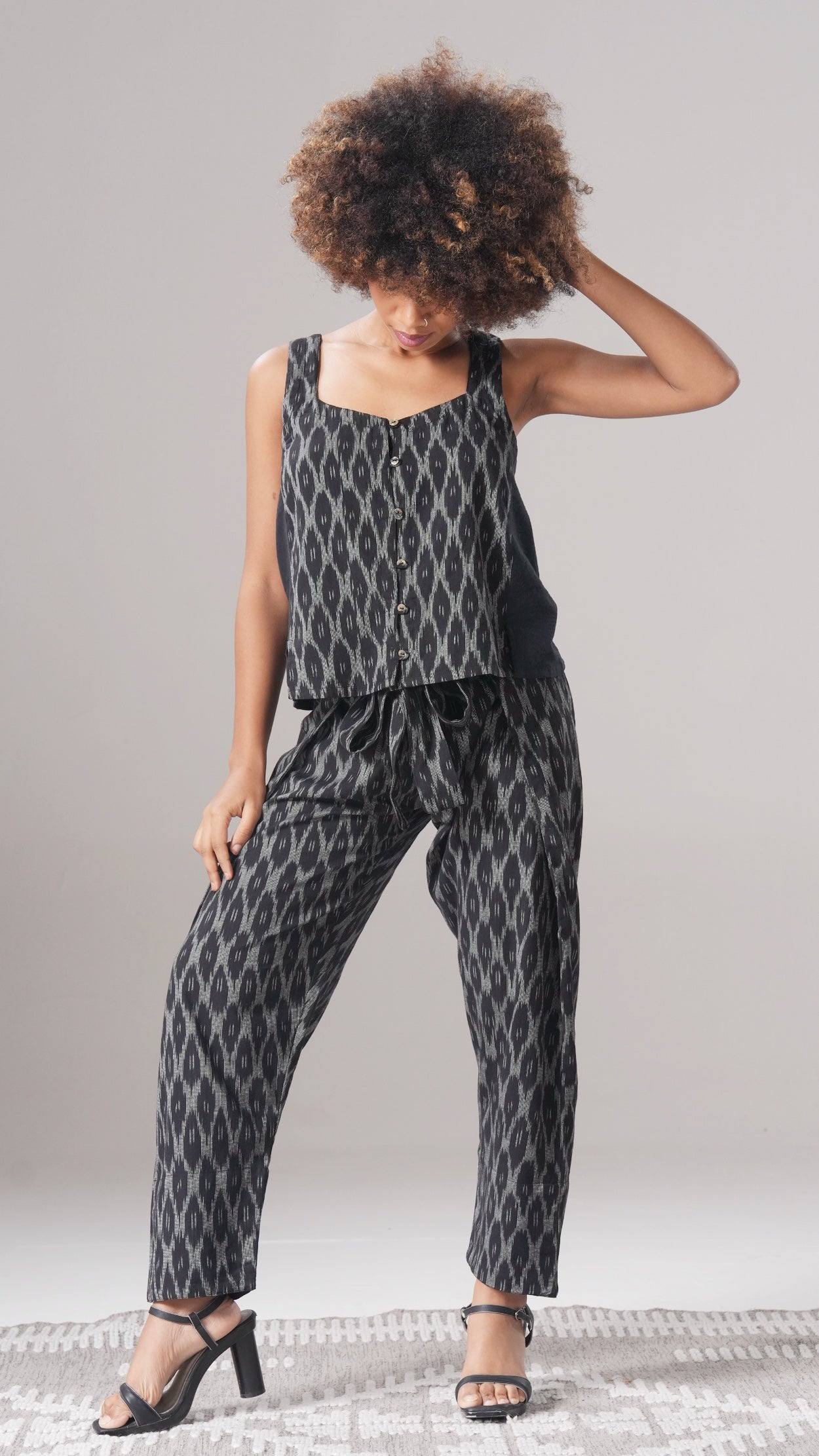 Woman wearing a black and white patterned outfit against a plain background
