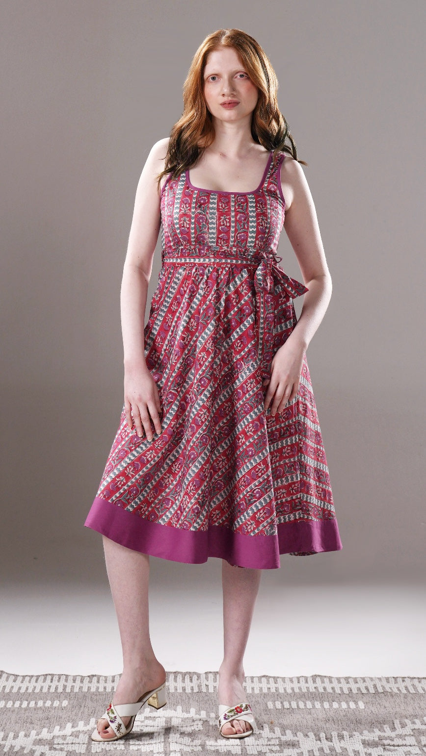 Woman wearing a patterned dress on a neutral background