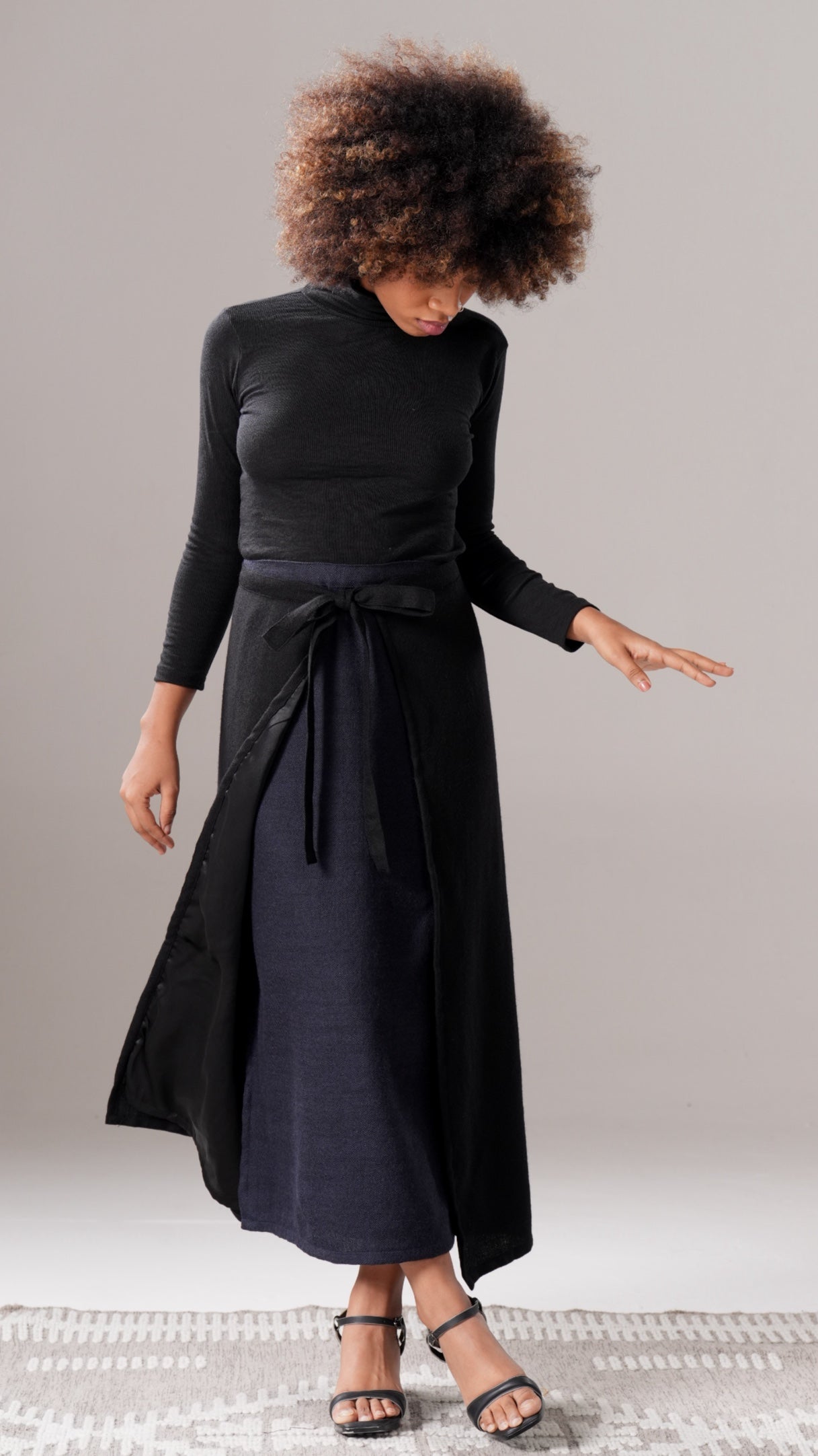 Woman wearing a black dress with a plain background