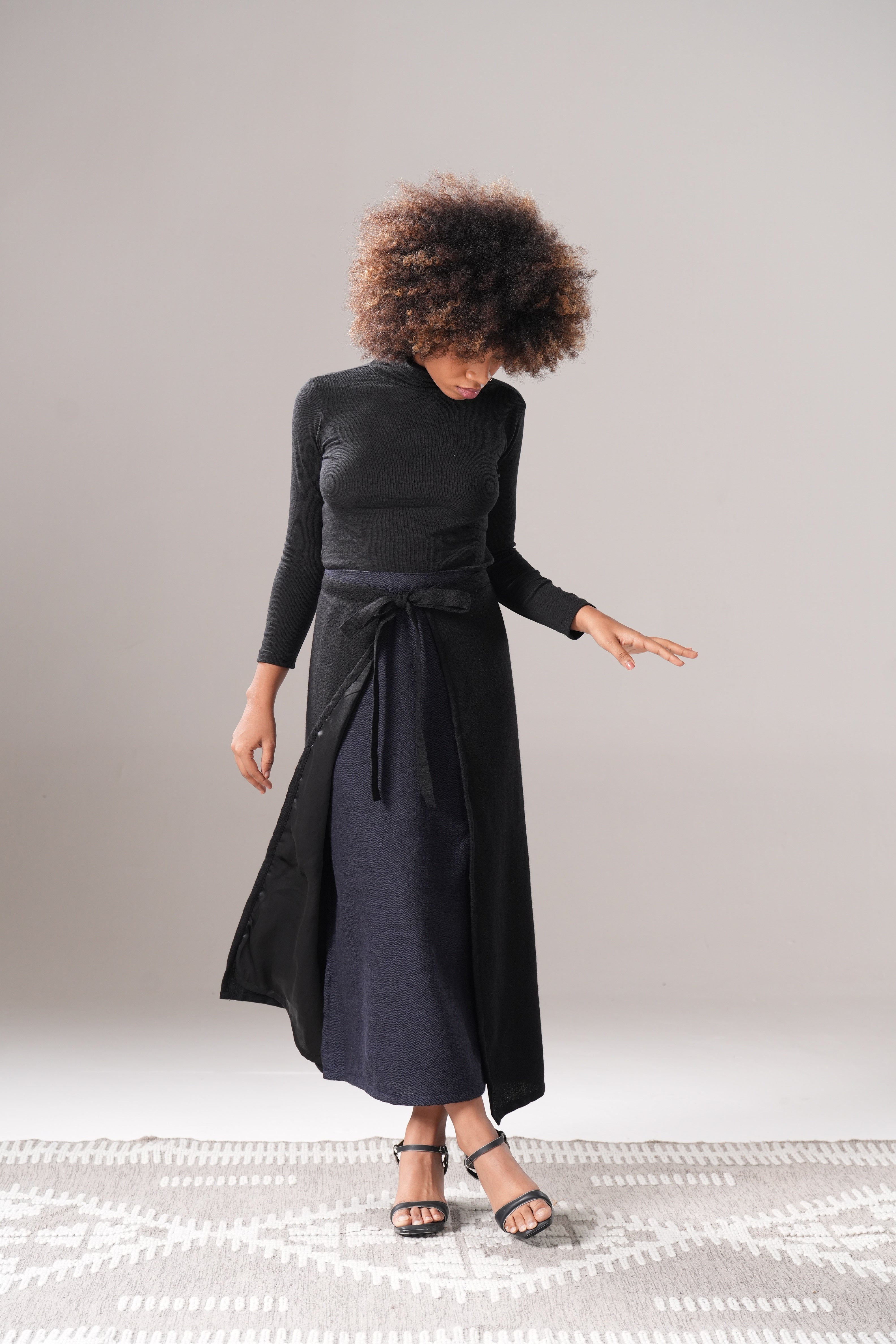 Person wearing a black outfit against a plain background