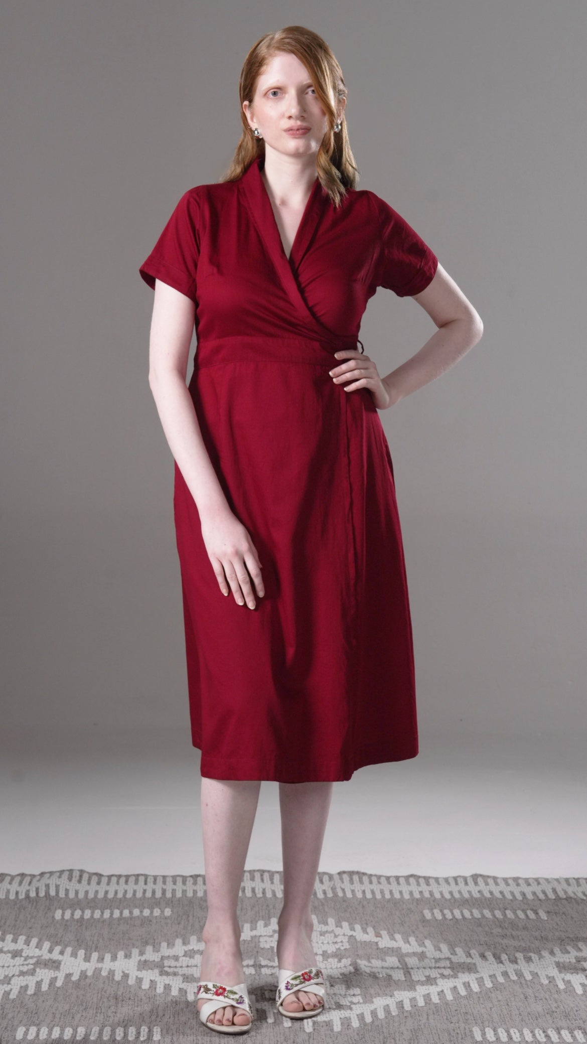 Woman wearing a red dress against a gray background