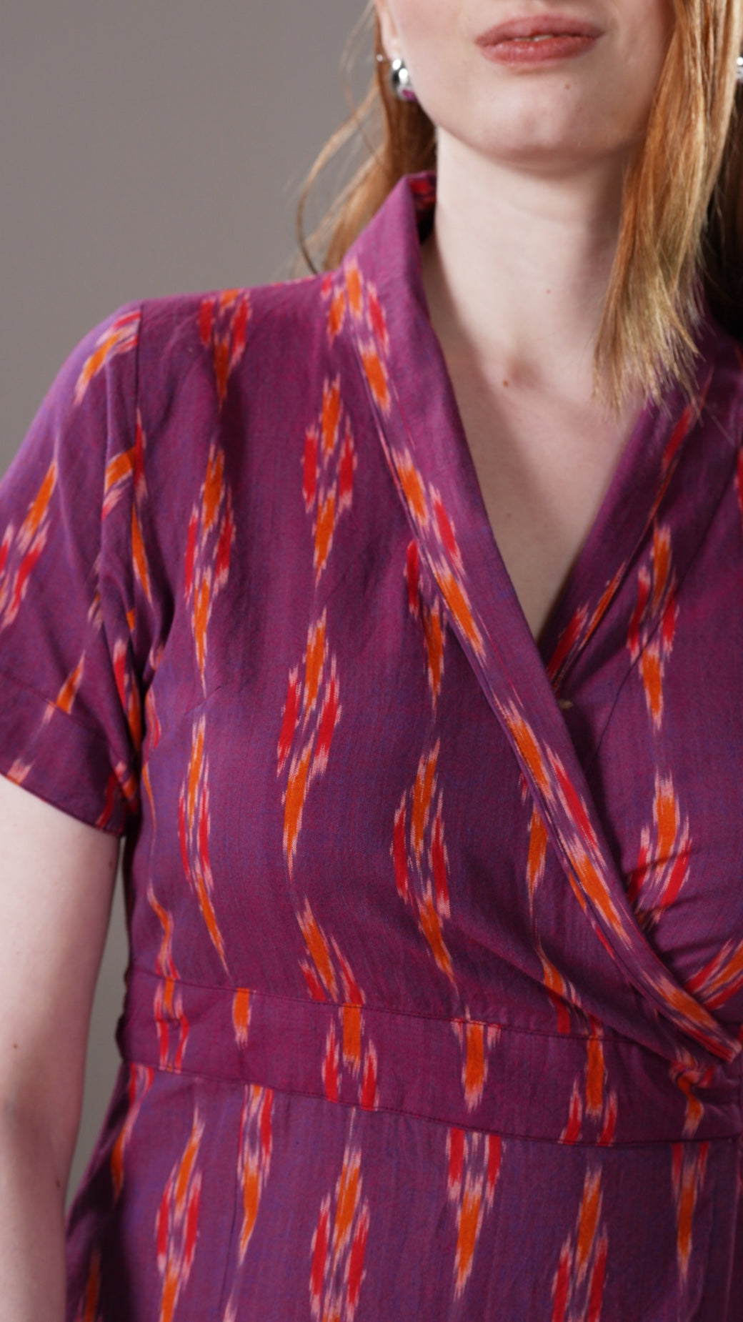 Close-up of a person wearing a purple dress with orange pattern