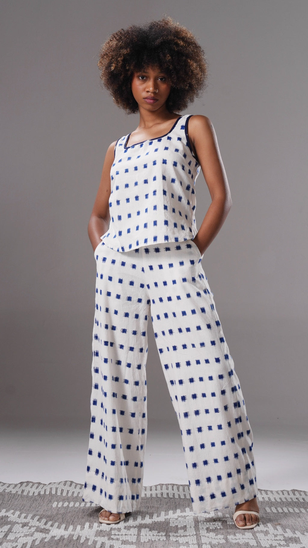 Woman wearing a white and blue checkered outfit on a gray background