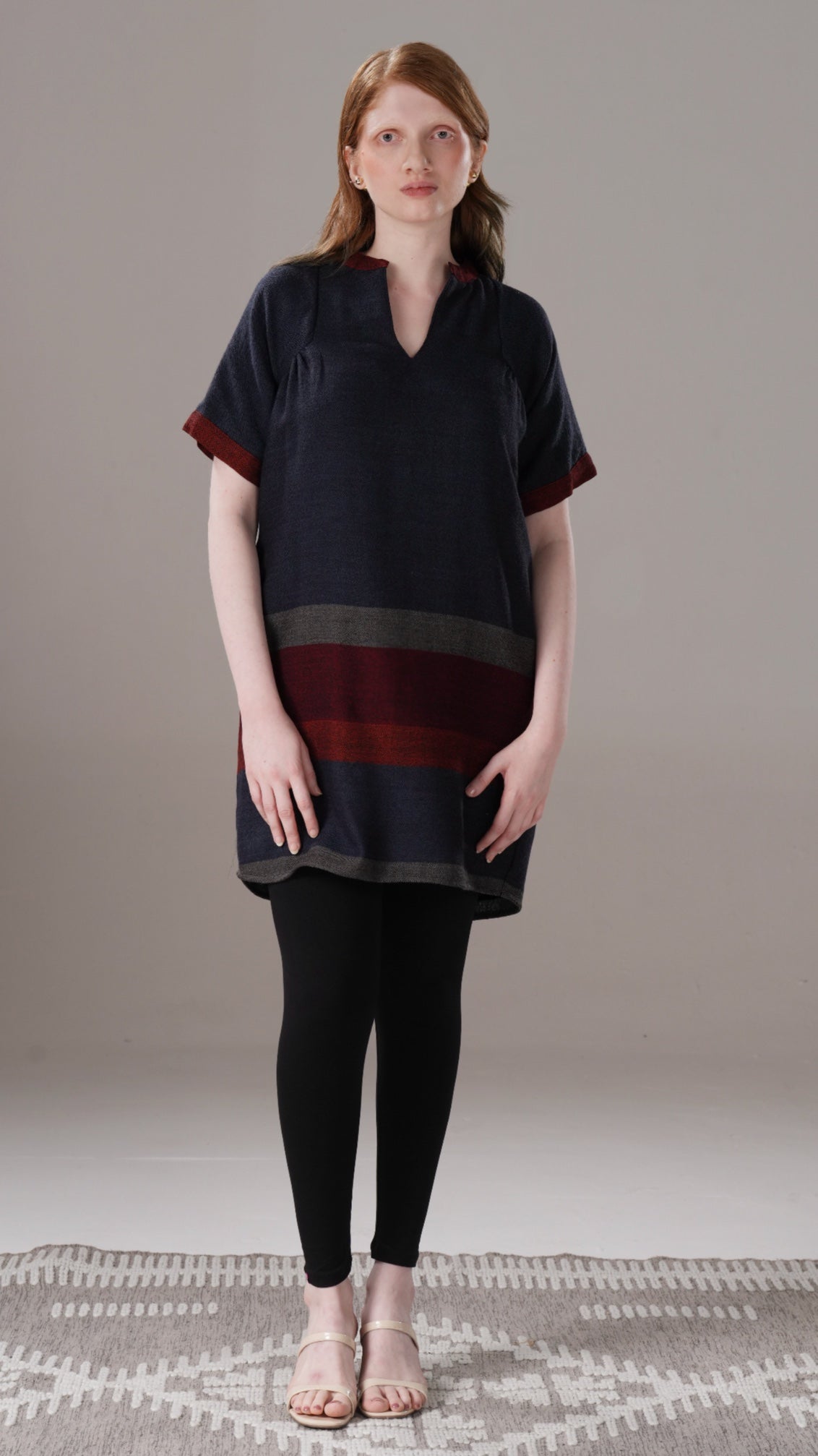 Woman wearing a black and red layered dress on a neutral background