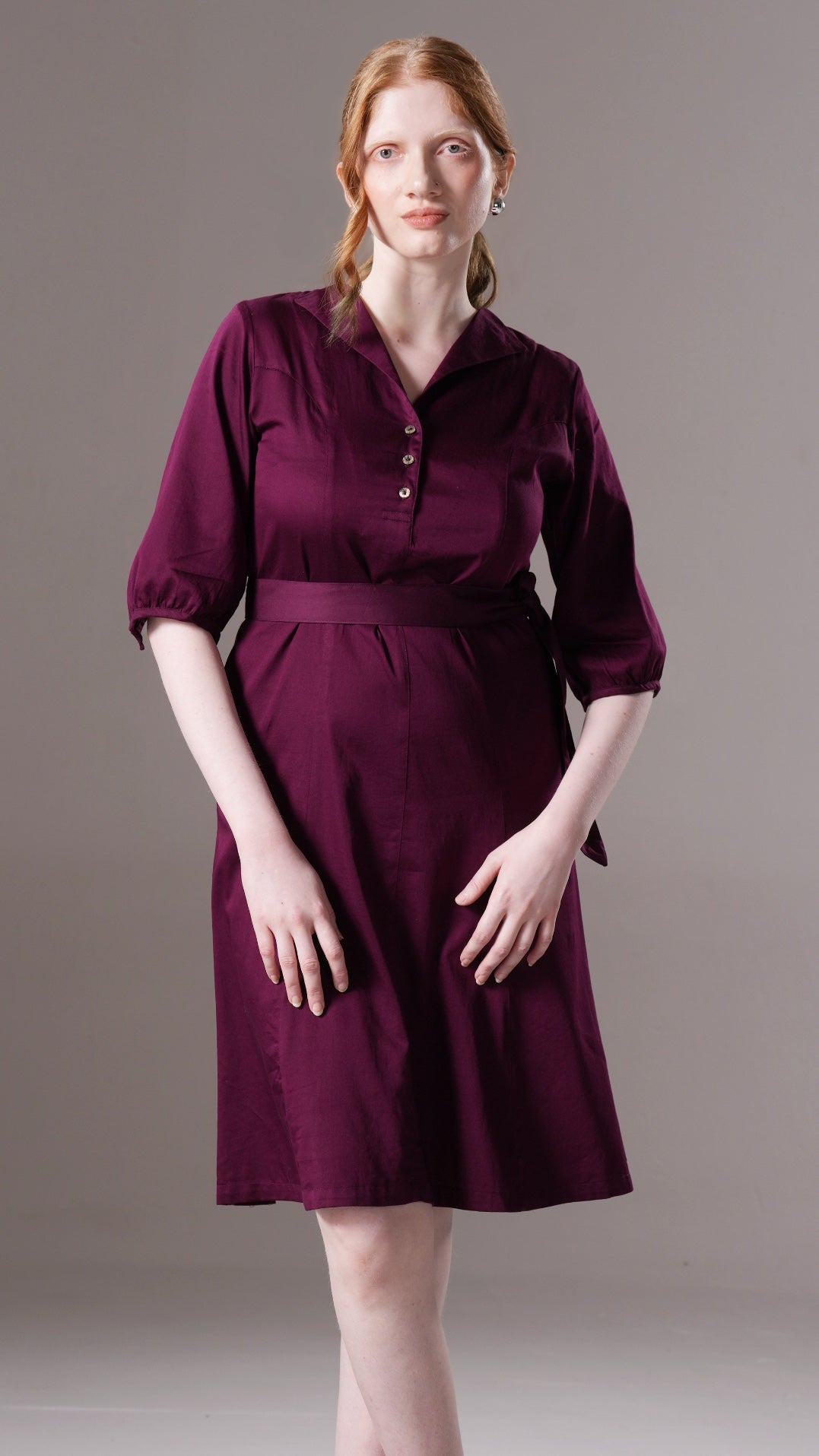 Woman wearing a purple dress against a plain background
