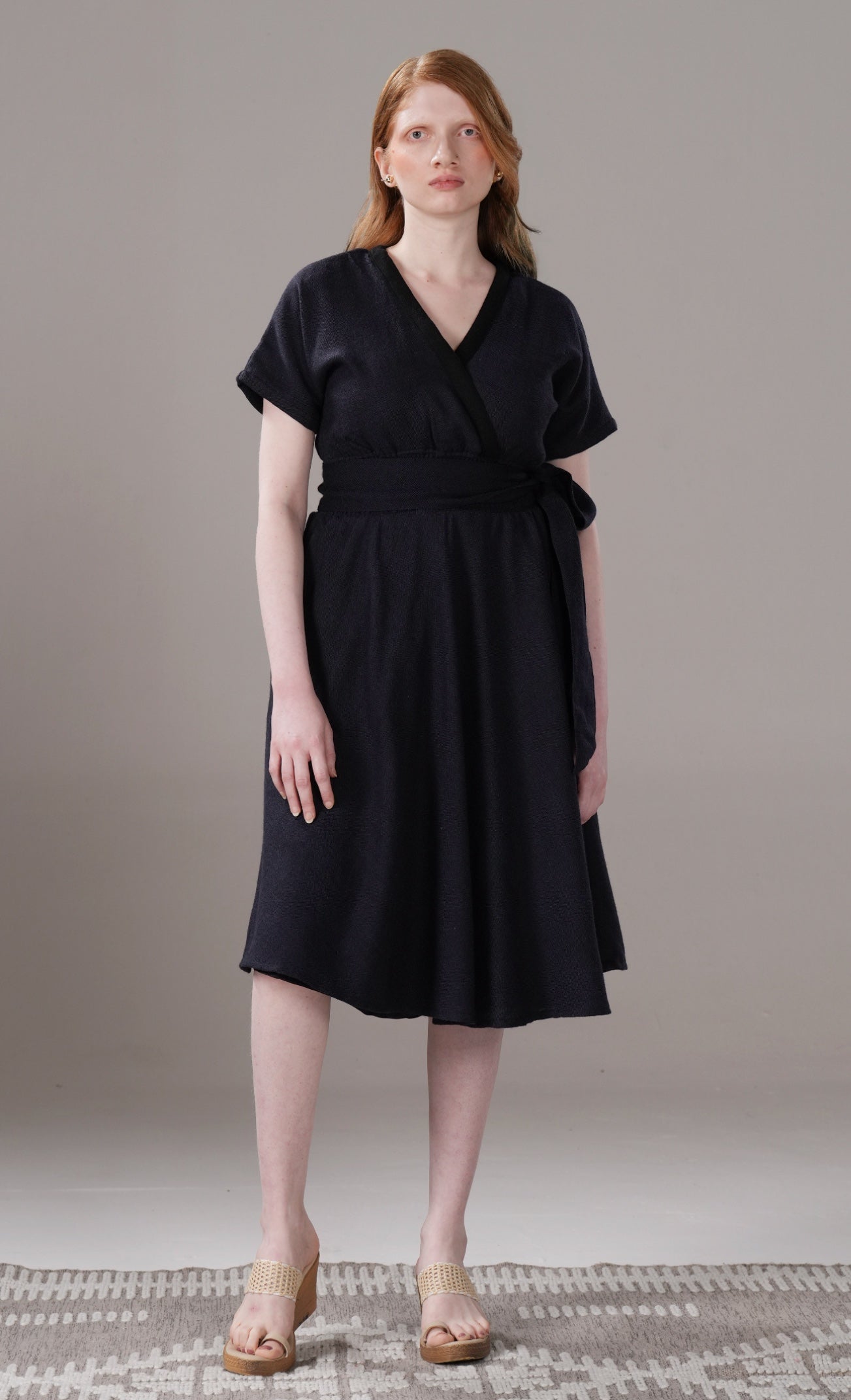 Woman wearing a black dress against a plain background